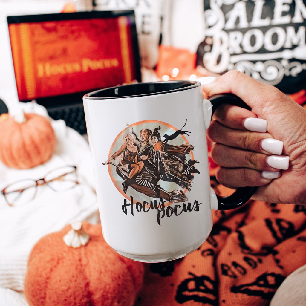 Picture of 15oz Black Handle Coffee Mug with Retro Sanderson Sisters flying on Vacuum Cleaner. Hocus Pocus in Black Lettering