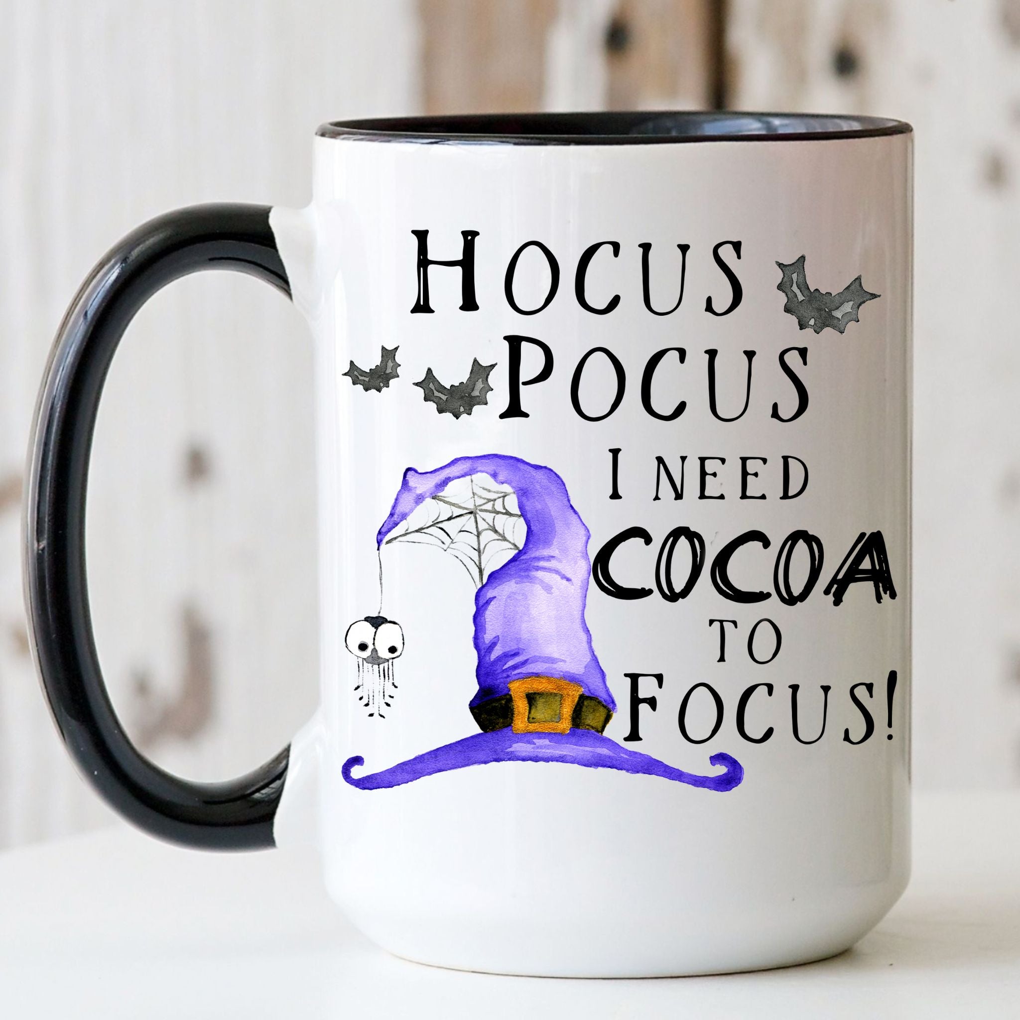 Picture of our 15oz Black Handle Coffee Mug with Graphic of Hocus Pocus I Need Cocoa To Focus on front of mug.